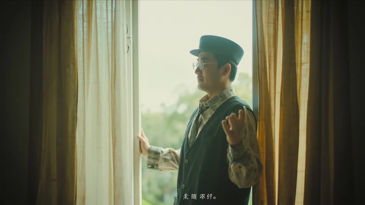 A person holds open a door, inviting someone to enter a room, illustrating “come” in Chinese: 来 (lái)